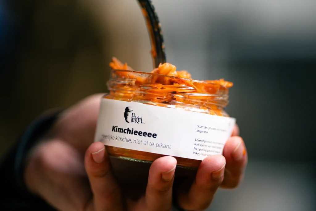 Een potje kimchi dat gevuld wordt in close-up