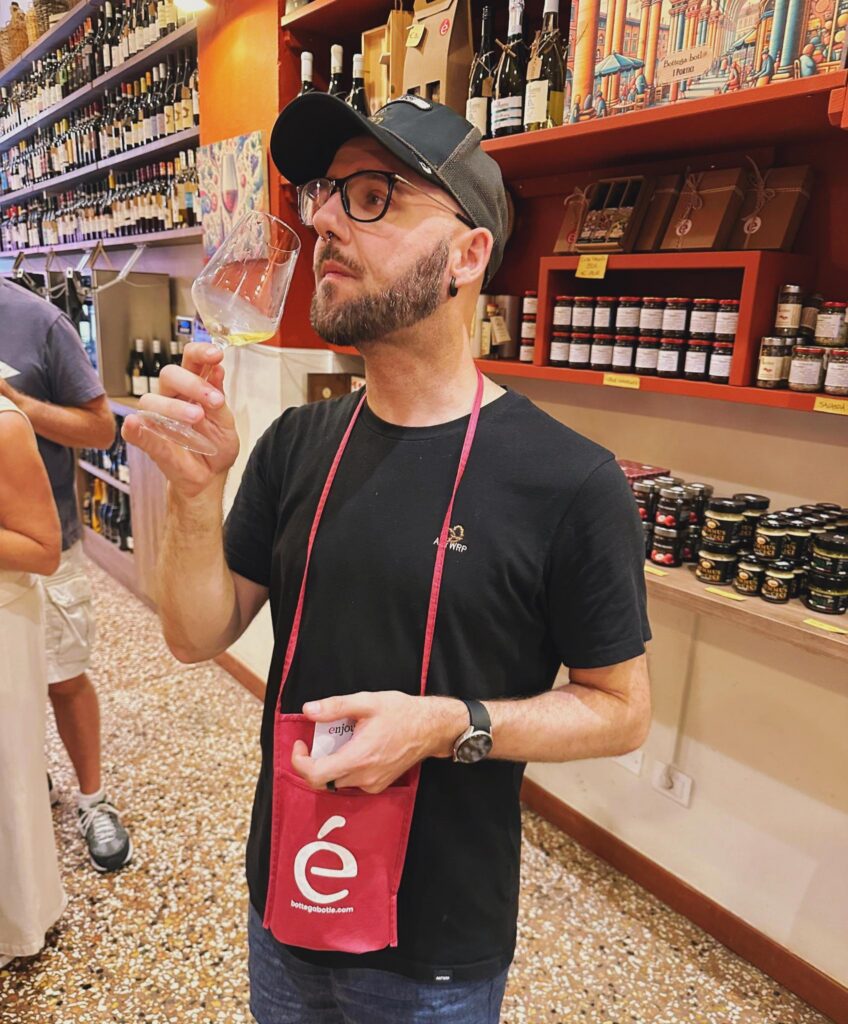 Sven in een bottega in Bologna, proevend van een glas witte wijn uit de regio