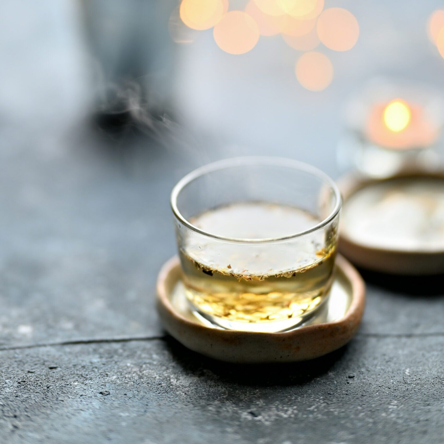 Een glas bloessemwijn op een houten onderzetter.