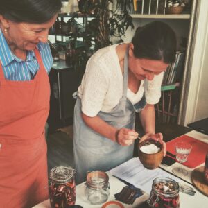 Twee dames die groenten aan het fermenteren zijn tijdens een workshop
